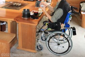 車いすの男性が食事をしているようす。