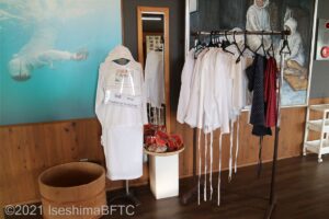 ハンガーラックに自由に着用できる磯着が5着ほどかかっている。磯着は白い木綿製。人型ボディーにも磯着が着せられていて、その横には昔ながらの水中眼鏡も置かれている。