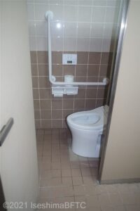 洋式トイレの個室のようす。一般のトイレと同じぐらいの広さ。奥の壁側にL字手すりが付いている。