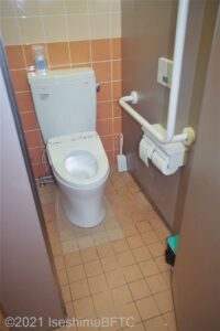 洋式トイレの個室のようす。一般のトイレと同じぐらいの広さ。便器に向かって右側の壁にL字手すりが付いている。