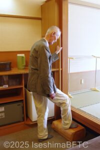 たて手すりを持って踏み台に上がり、和室へ入ろうとしているお客さま
