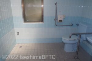 木場公園車いす対応トイレ　便器に向かって右側にJ型固定手すり、左側にL型固定手すり
