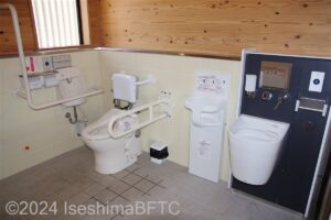 的矢あんしんトイレ　車いす対応トイレ大　便器に向かって右側にU型可動手すり、左側にL型固定手すり　便器の右にベビーチェアとオストメイト