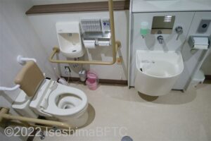 阿児アリーナ　オーシャンホール車いす対応トイレ　便器に向かって右側にL型固定手すり、左側にU型可動手すり