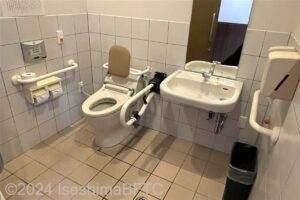 長太屋車いす対応トイレ内部　入口からみて左奥に、たて置きに便器。入口からみて正面に洗面台