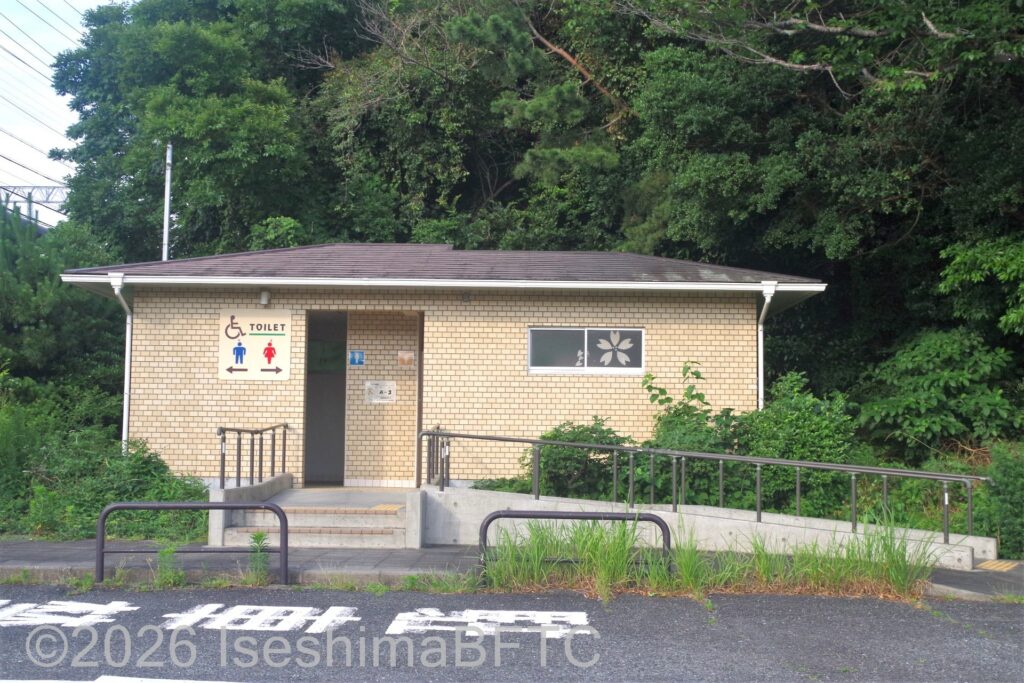 賢島駅南口駐車場トイレ棟を入口方向から見たところ。正面に階段、右側にスロープがある
