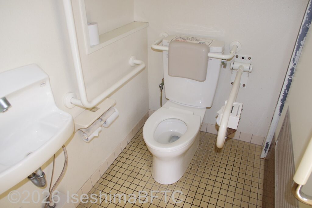 賢島駅南口駐車場車いす対応トイレ便器まわり　便器に向かって右側にU型可動手すり、左側にL型固定手すり