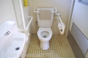 賢島駅南口駐車場車いす対応トイレ便器まわり　便器に向かって右側にU型可動手すり、左側にL型固定手すり