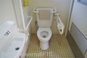 賢島駅南口駐車場車いす対応トイレ便器まわり　便器に向かって右側にU型可動手すり、左側にL型固定手すり