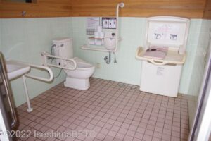 横山展望台駐車場車いす対応トイレ内部　入口からみて左奥に、よこ置きに便器。入口からみて左手前に洗面台