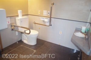 横山展望台　天空カフェテラス車いす対応トイレ内部　入口からみて左奥に、よこ置きに便器。入口からみて右奥に洗面台