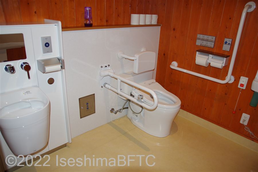 創造の森横山作業所　車いす対応トイレ便器まわりとオストメイト　便器に向かって右側にL型固定手すり、左側にU型可動手すり
