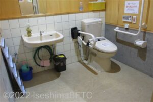 志摩パークゴルフ場車いす対応トイレ内部　入口からみて右奥に、たて置きに便器。入口からみて正面に洗面台