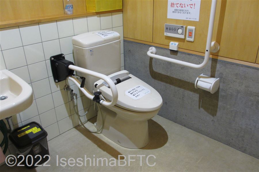 志摩パークゴルフ場車いす対応トイレ便器まわり　便器に向かって右側にL型固定手すり、左側にU型可動手すり