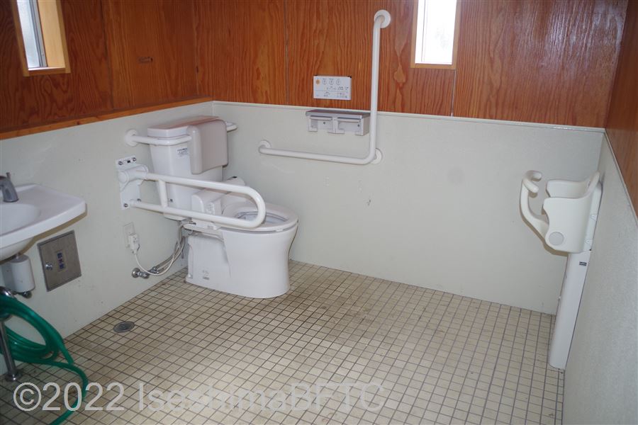 あのり　浦の浜公衆トイレ車いす対応トイレ内部　入口からみて左奥に、よこ置きに便器。入口からみて左手前に洗面台