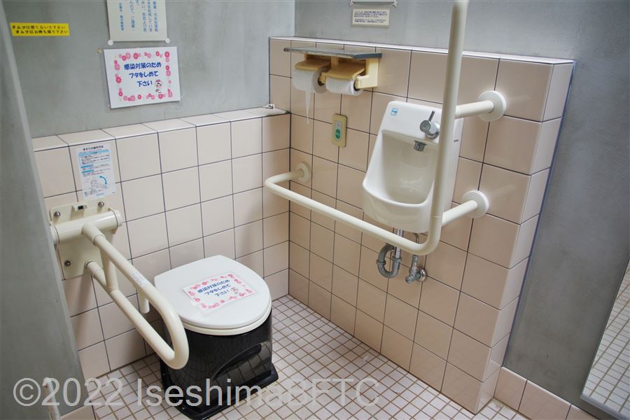 国府白浜園地休憩舎車いす対応トイレ便器まわり　便器に向かって右側にL型固定手すり、左側にU型可動手すり