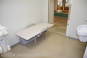 志摩市役所1階車いす対応トイレ　ユニバーサルシートを下ろしたようすを、室内側から見たところ