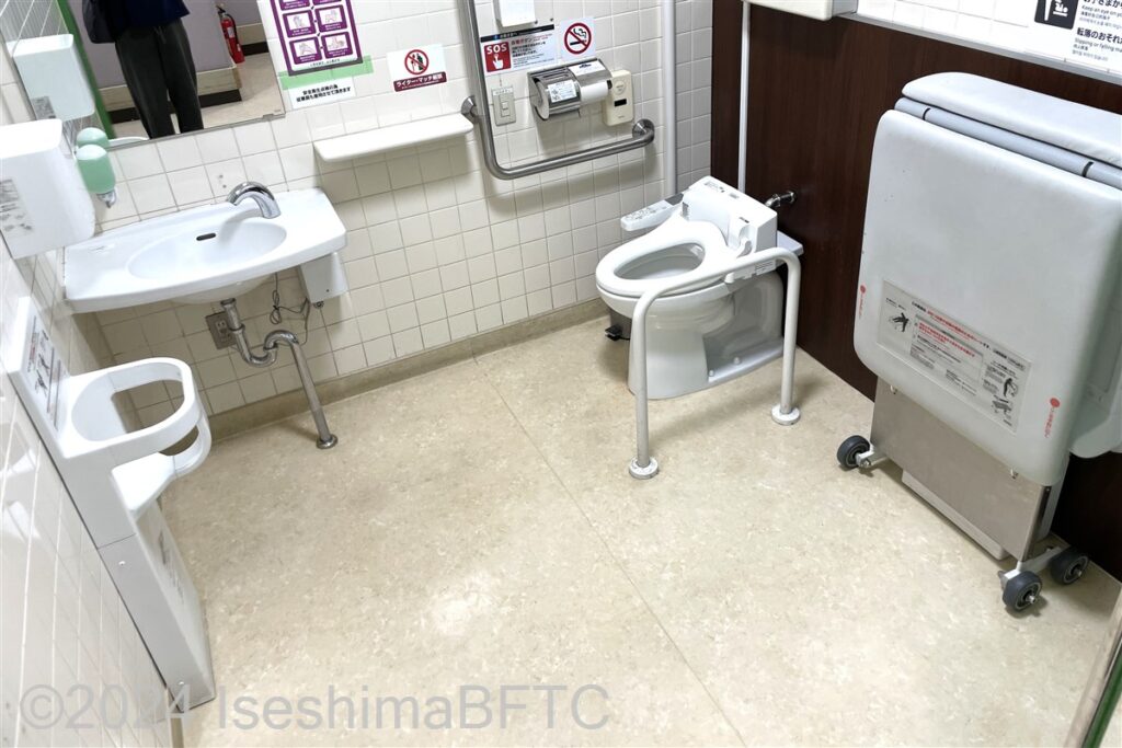 イオン阿児店1階車いす対応トイレ内部　入口からみて右奥に、よこ置きに便器。入口からみて左奥に洗面台