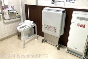 イオン阿児店1階車いす対応トイレ　入口側から奥へ、おむつボックス・ユニバーサルシート・便器の順で並んでいるようす
