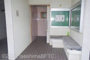 波切漁港トイレパーク車いす対応トイレ内部　入口正面に、よこ置きに便器。入口の右手前に洗面台