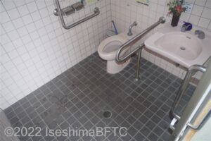 波切漁港トイレパーク車いす対応トイレ内部　入口からみて右奥に、よこ置きに便器。入口からみて右手前に洗面台