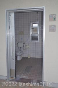 波切漁港環境公園車いす対応トイレ内部　入口正面に、よこ置きに便器。入口の右手前に洗面台