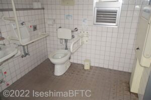 波切漁港環境公園車いす対応トイレ内部　入口からみて左奥に、たて置きに便器。入口からみて左手前に洗面台
