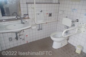 波切漁港環境公園車いす対応トイレ便器まわり　便器に向かって右側にU型可動手すり、左側にL型固定手すり