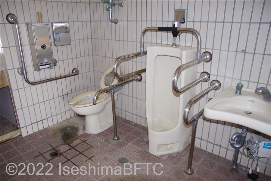 志摩総合スポーツ公園多目的広場車いす対応トイレ便器回り　便器に向かって右側にJ型固定手すり、左側にL型固定手すり