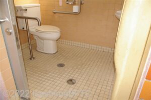 浜島ふるさと公園車いす対応トイレ内部　入口からみて左奥に、よこ置きに便器。入口からみて右奥に手洗い