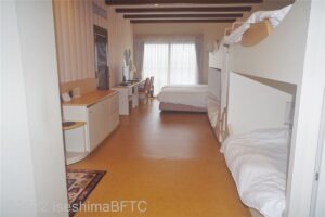 室内の窓際にはベッドが2台、その手前に2段ベッドが2つ置かれていて、6名まで宿泊可能。ベッドには白いシーツがかかっている。