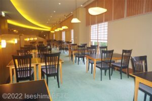 日本料理「志摩」の店内のうようす。イスは黒い木製。カーペットの色はうすい緑色をしている。