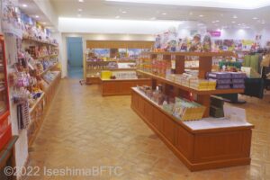 1階の売店のようす。木製の陳列棚にキャラクターグッズやお菓子などが並ぶ。