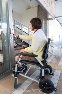 インターフォンでスタッフに連絡している車いす使用者