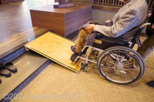 簡易スロープを車いすで上がるようす