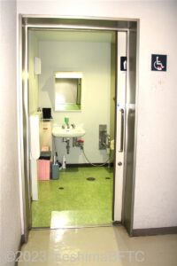 Ｈゾーントイレ内部のようす　入口からみて右奥に、たて置きに便器。入口正面に洗面台