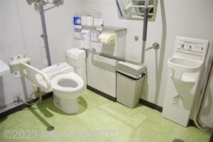 中2階車いす対応トイレ便器まわり　入口からみて右奥に、たて置きに便器。左奥に洗面台