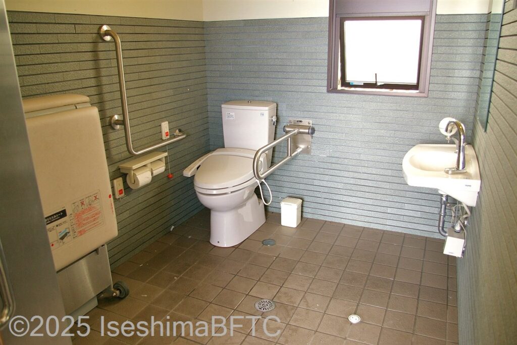 国崎漁港公衆トイレ内部　入口からみて左奥に、たて置きに便器。入口からみて右奥に洗面台