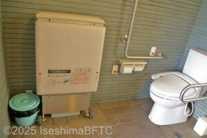 国崎漁港公衆トイレ　右側に便器、左側に二つ折りに畳まれたユニバーサルシート