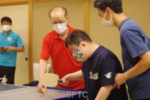 支えてもらいながらサーブを打つところ