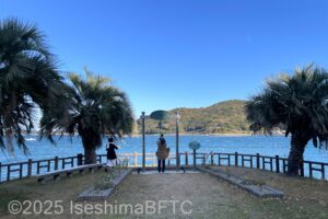 岬の鐘を鳴らしている人物の遠景