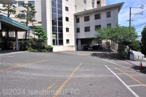 右側の道路から左側の入口への坂を横から見たところ