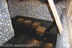 風水貝殻風呂　浴槽内に腰掛け用の石が4つ沈んでいる