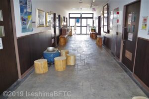 廊下の奥にわんぱく磯につながるガラスの扉が見える。