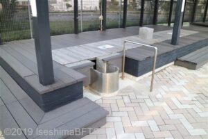 車いすでも利用しやすいように工夫された足湯。ステンレス製の楕円の浴槽が飛べ出ている形になっていて、車いすの方も足湯に近づきやすくなっている。手すりも設置されている。