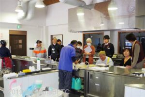「てこね道場」でてこね寿司作りに体験をしているお客さんのようす。中央にいるスタッフが魚をおろしているのが見える。
