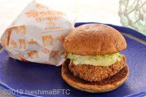 かつおバーガーのようす。丸いパンの間にタルタルソースがたっぷりかかったカツオのフライが挟まれている。
カツオバーガーの「かつ」の文字は、勝負に勝つの漢字が使われていて、縁起の良いネーミングになっている。