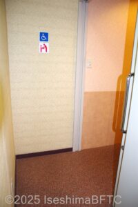 通路奥の右側にある車いす対応トイレ入口