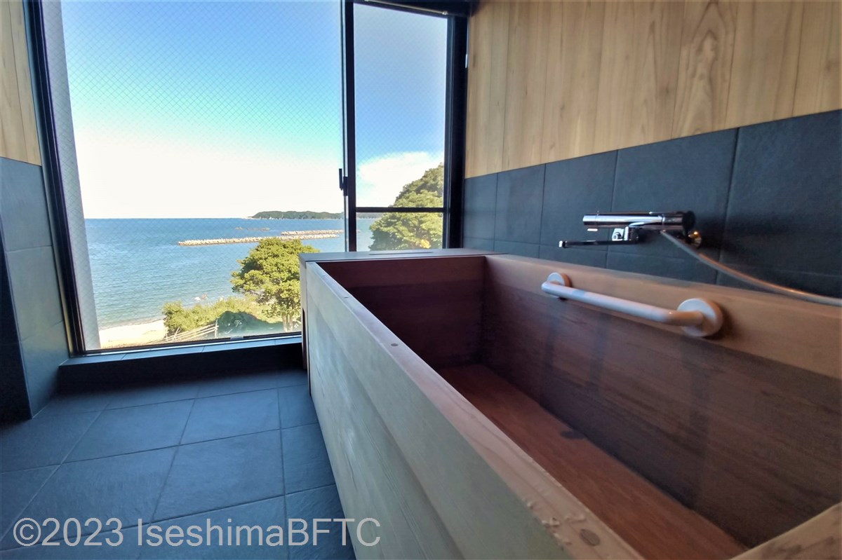 ユニバーサルデザインルーム　浴室からの景色　木々の向こうに海が見える