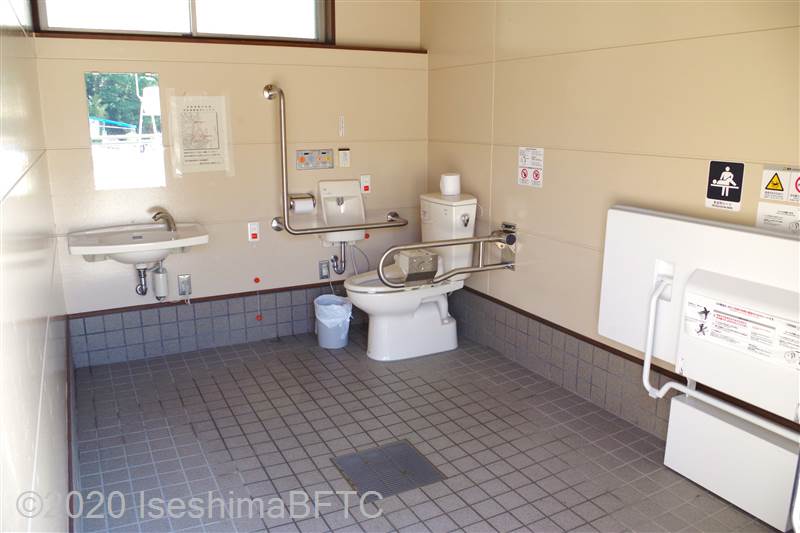 安楽島海水浴場車いす対応トイレ内部　入口からみて右奥に、よこ置きに便器。入口からみて左奥に洗面台